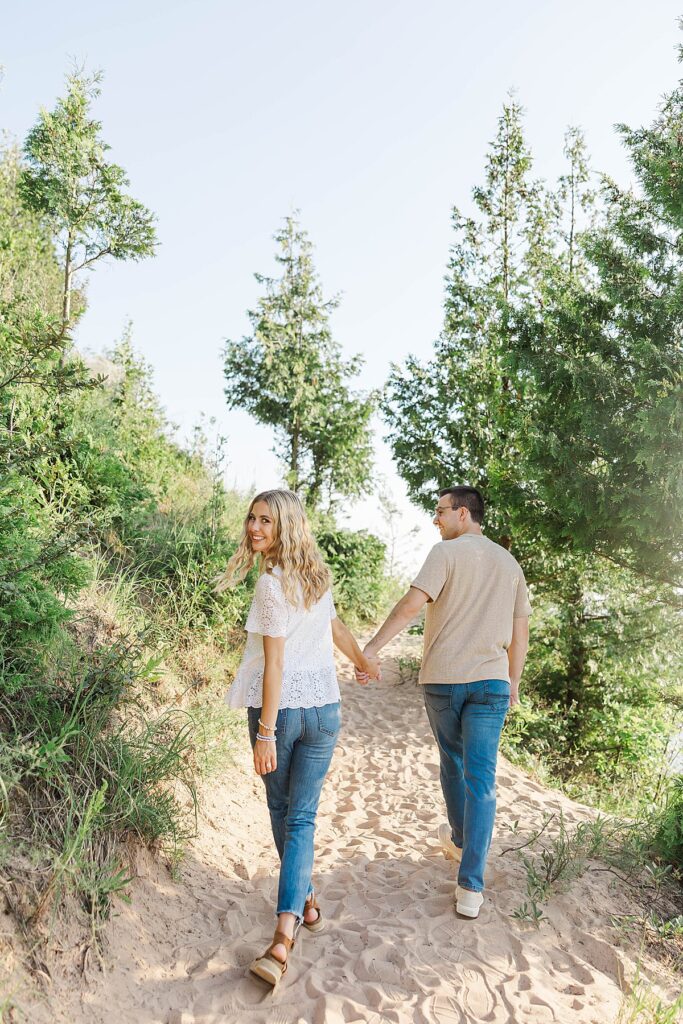 Couple walking hand in hand during Empire Bluff engagement session