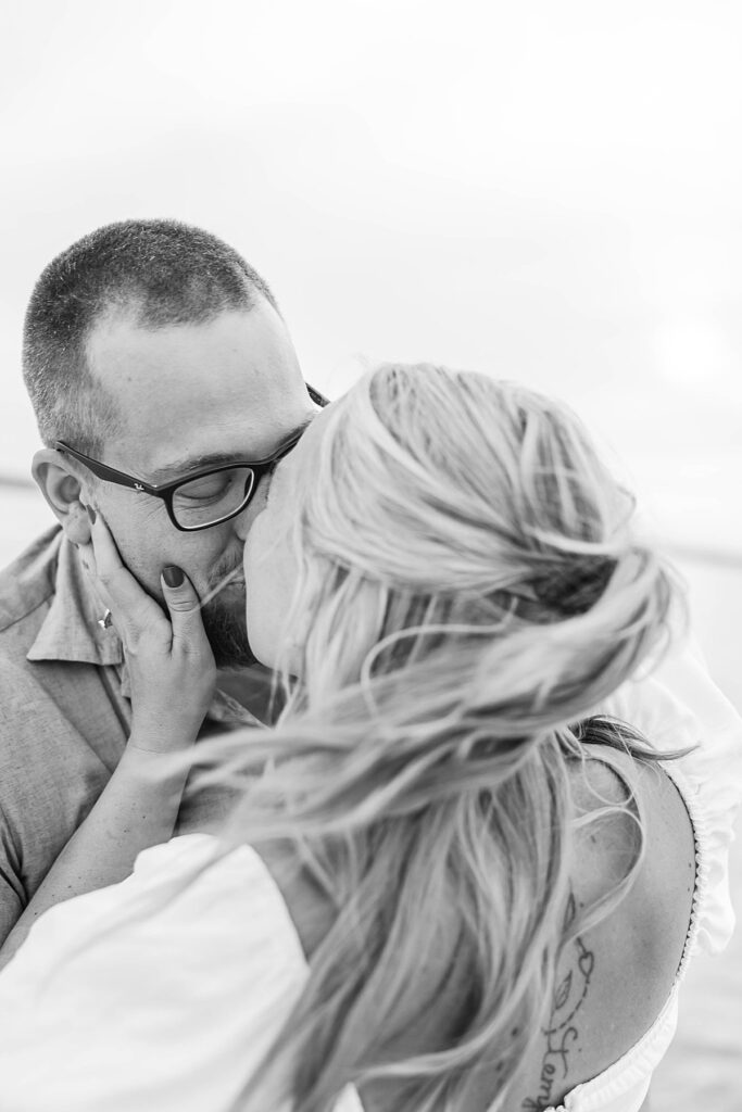 Candid engagement portraits on the sand with Lake Michigan in the background