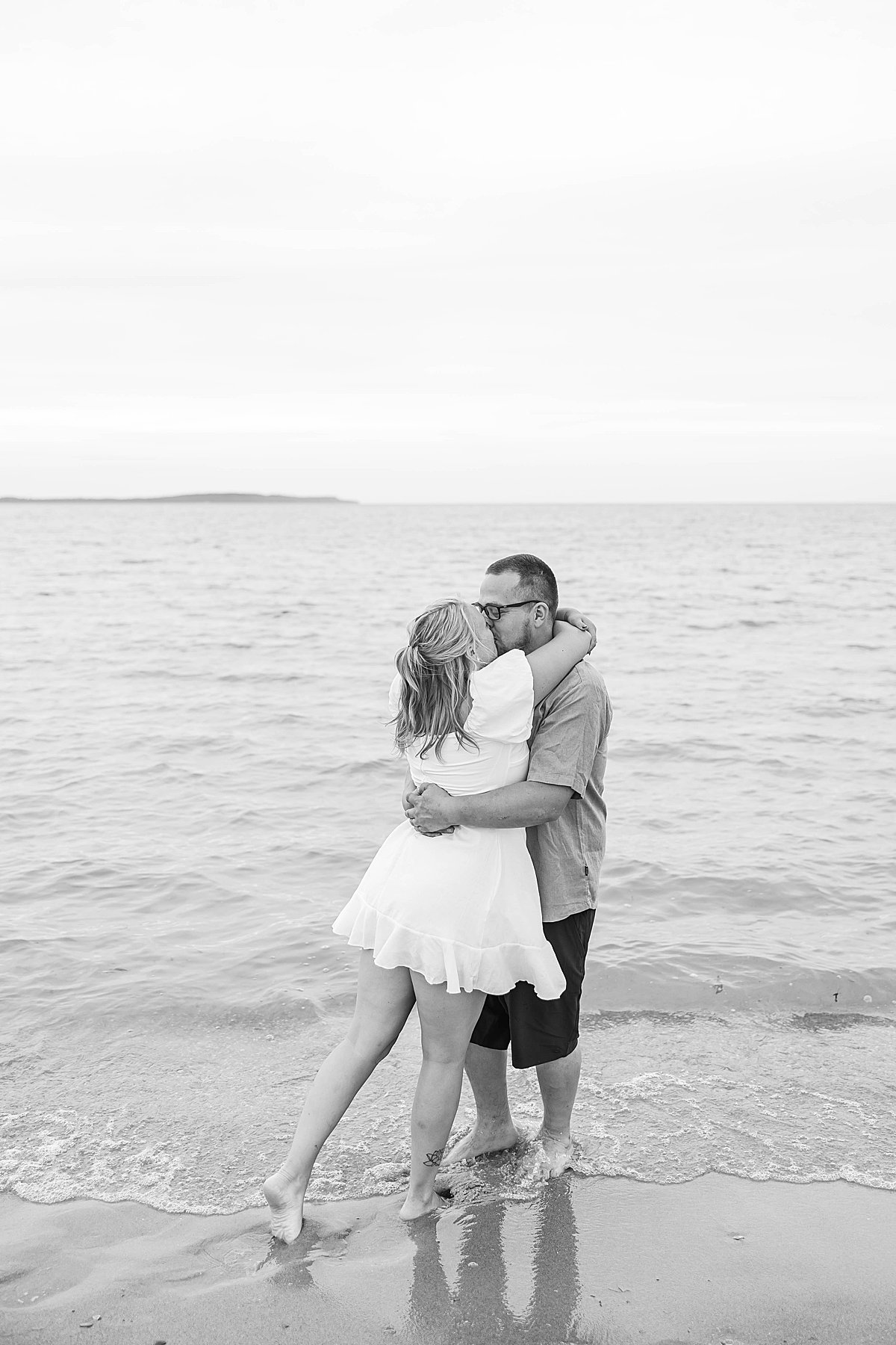 Couple wading into the water during an Elk Rapids beach engagement session