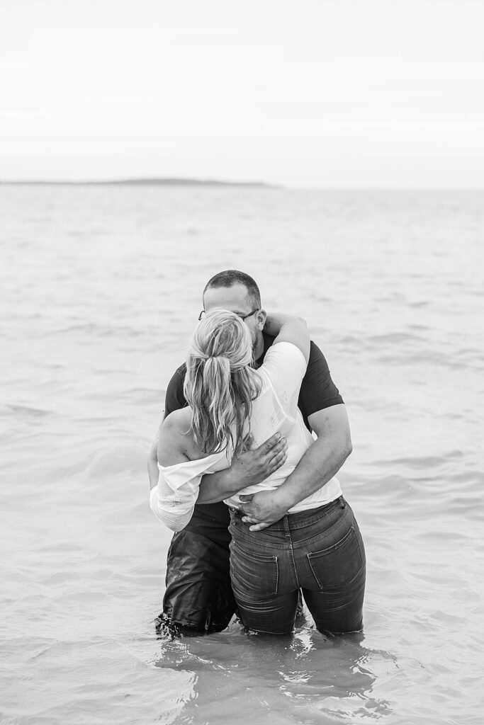 Couple wading into the water during an Elk Rapids beach engagement session