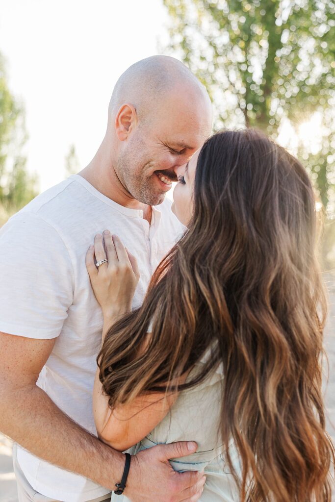 Parents laughing together along the Elk Rapids shoreline