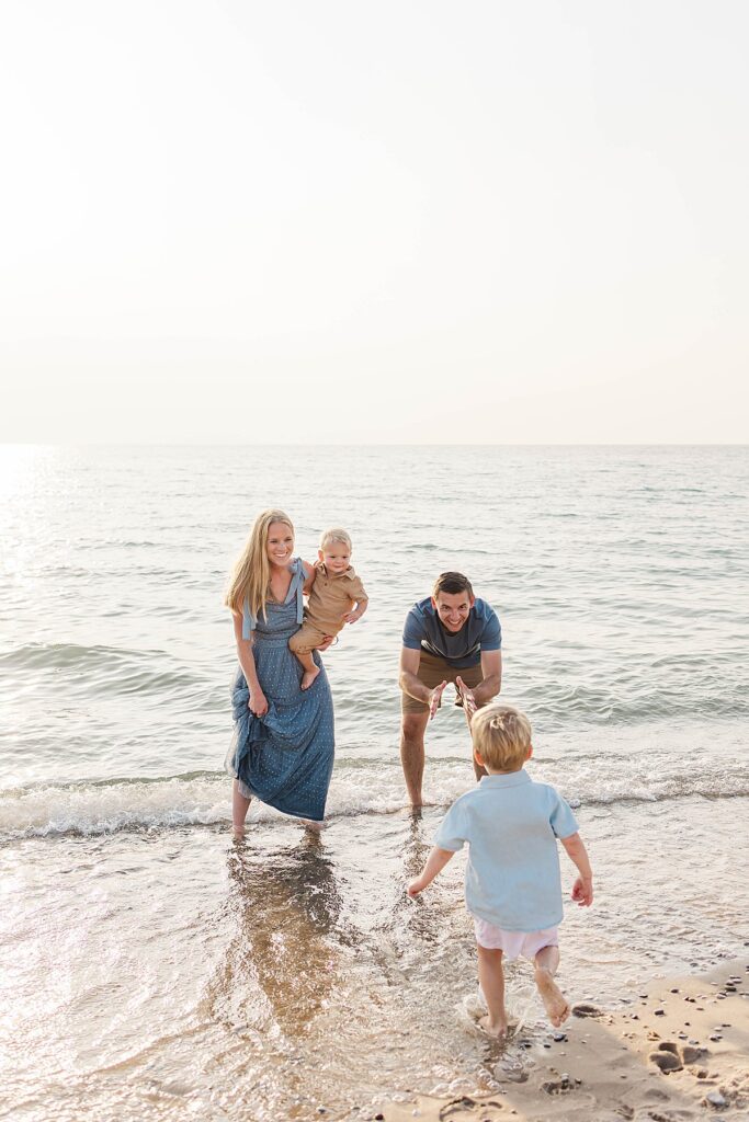 Family laughing and playing along the shoreline at Empire Beach