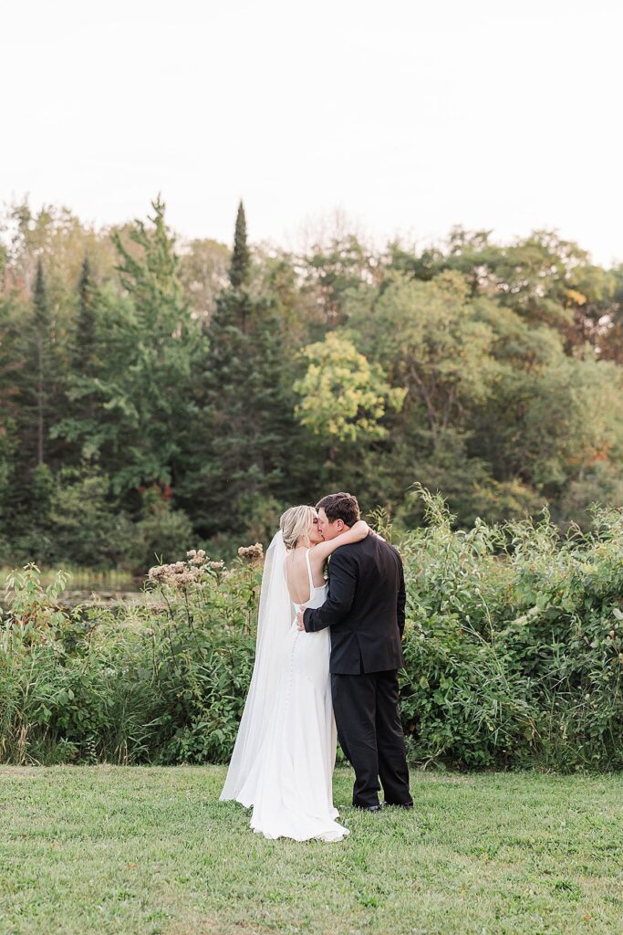 Sunset portraits of bride and groom near the pond at Mill Pond Event Center