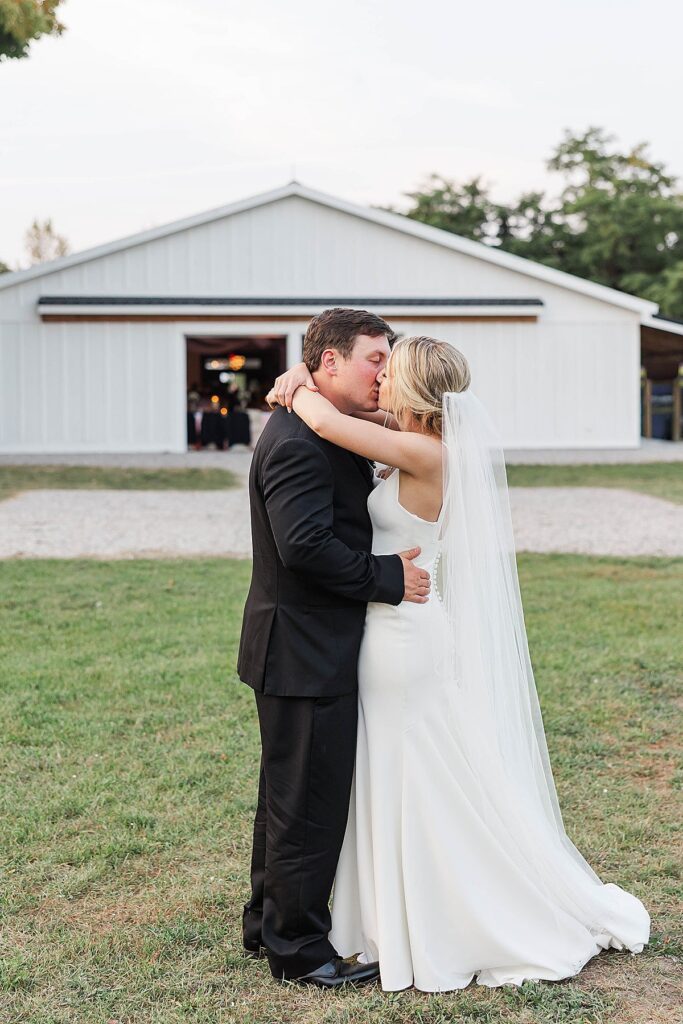 Bride and groom walking back to Mill Pond Event Center after sunset portraits