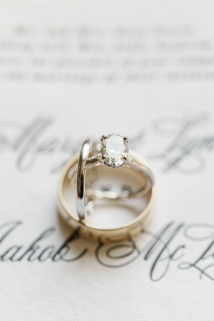 Wedding rings displayed on calligraphy invitation suite at a Northern Michigan fall wedding