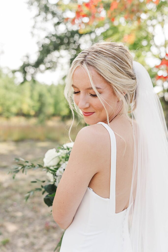Bride looking over her shoulder during fall wedding portraits in Northern Michigan
