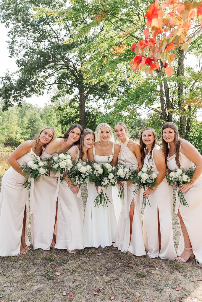 Bride and bridesmaids sharing a candid moment during wedding portraits