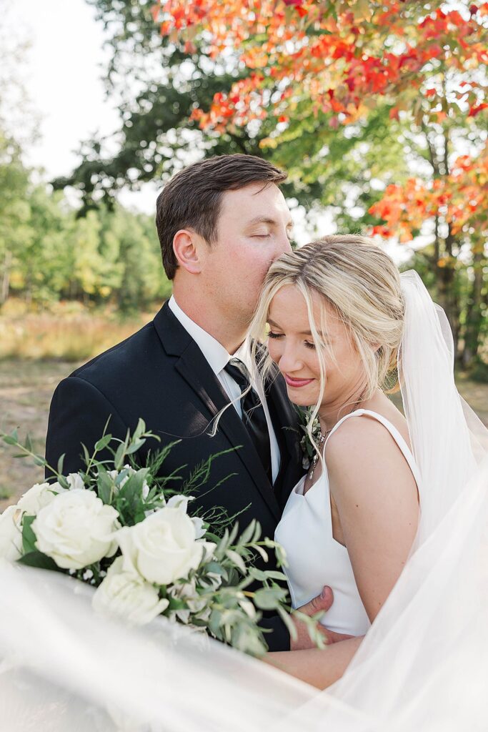 Bride and groom surrounded by fall colors during Northern Michigan wedding portraits