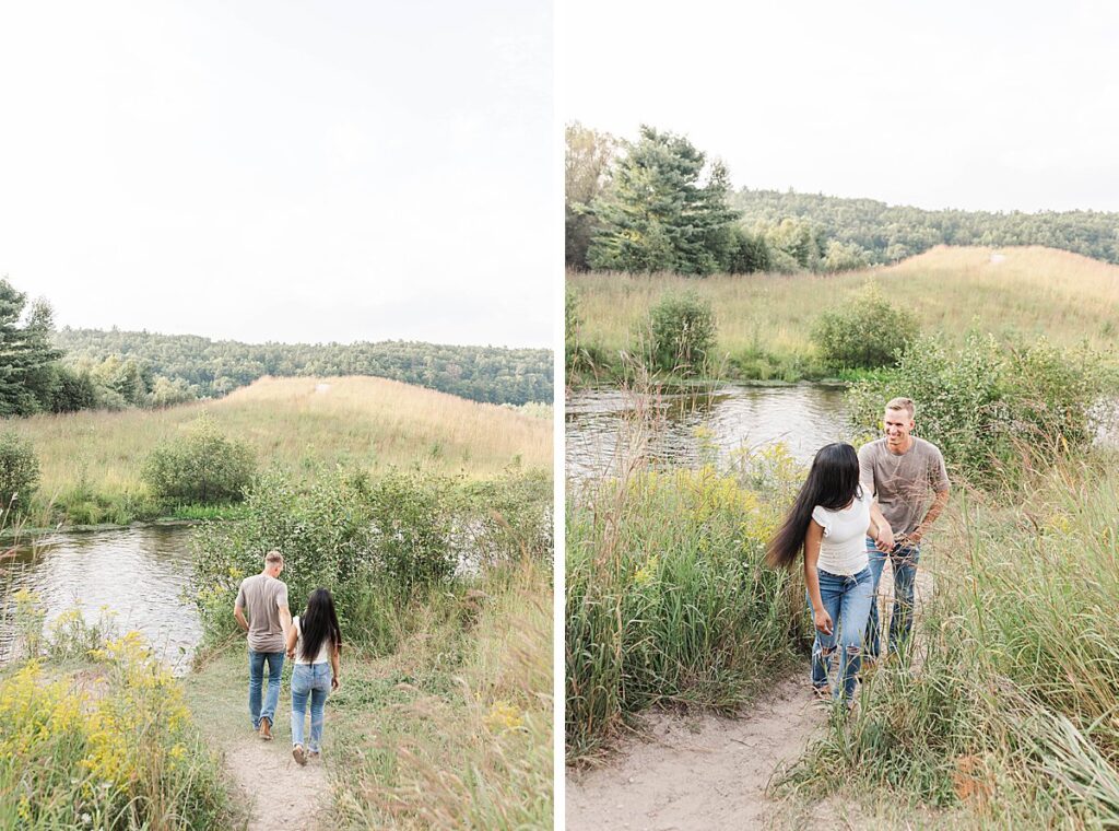 Engaged couple walking together through tall grass during a Northern Michigan engagement session.