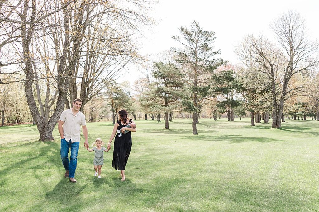 Springtime newborn photography with parents and baby outdoors