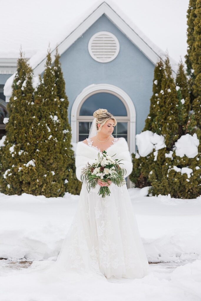 Bride standing in her wedding dress during winter wedding morning preparations