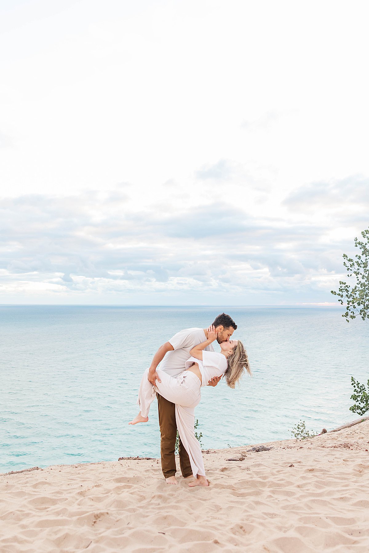 Couple embracing during engagement photos at Pierce Stocking Scenic Drive in Sleeping Bear Dunes