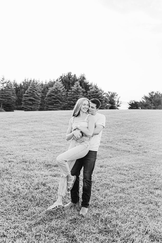Relaxed couple walking through a field on family property in Michigan