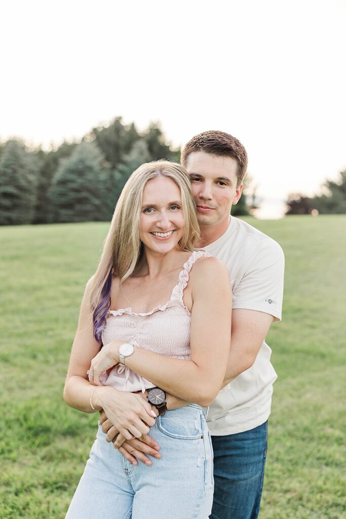 Candid engagement photos in an open field during a Michigan engagement session