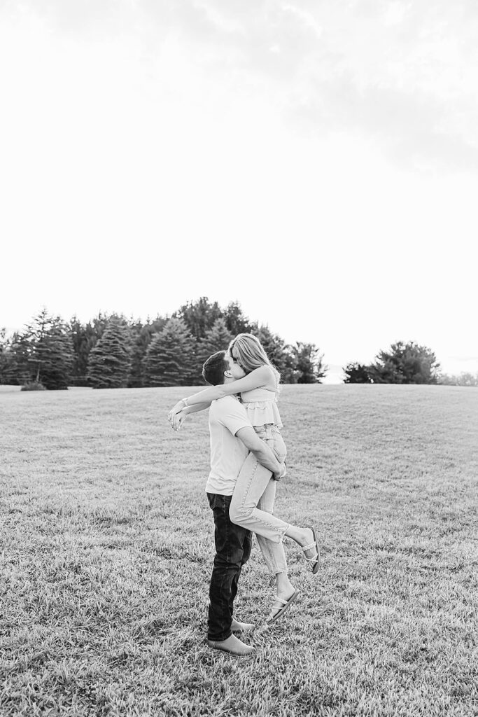 Relaxed couple walking through a field on family property in Michigan