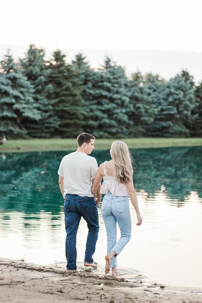 Couple walking toward the pond during a Michigan engagement session