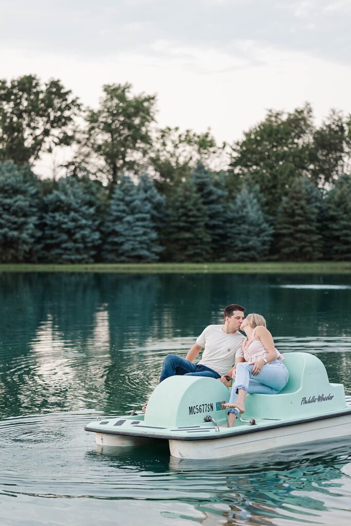 Unique engagement photos in a rowboat on a family pond in Michigan