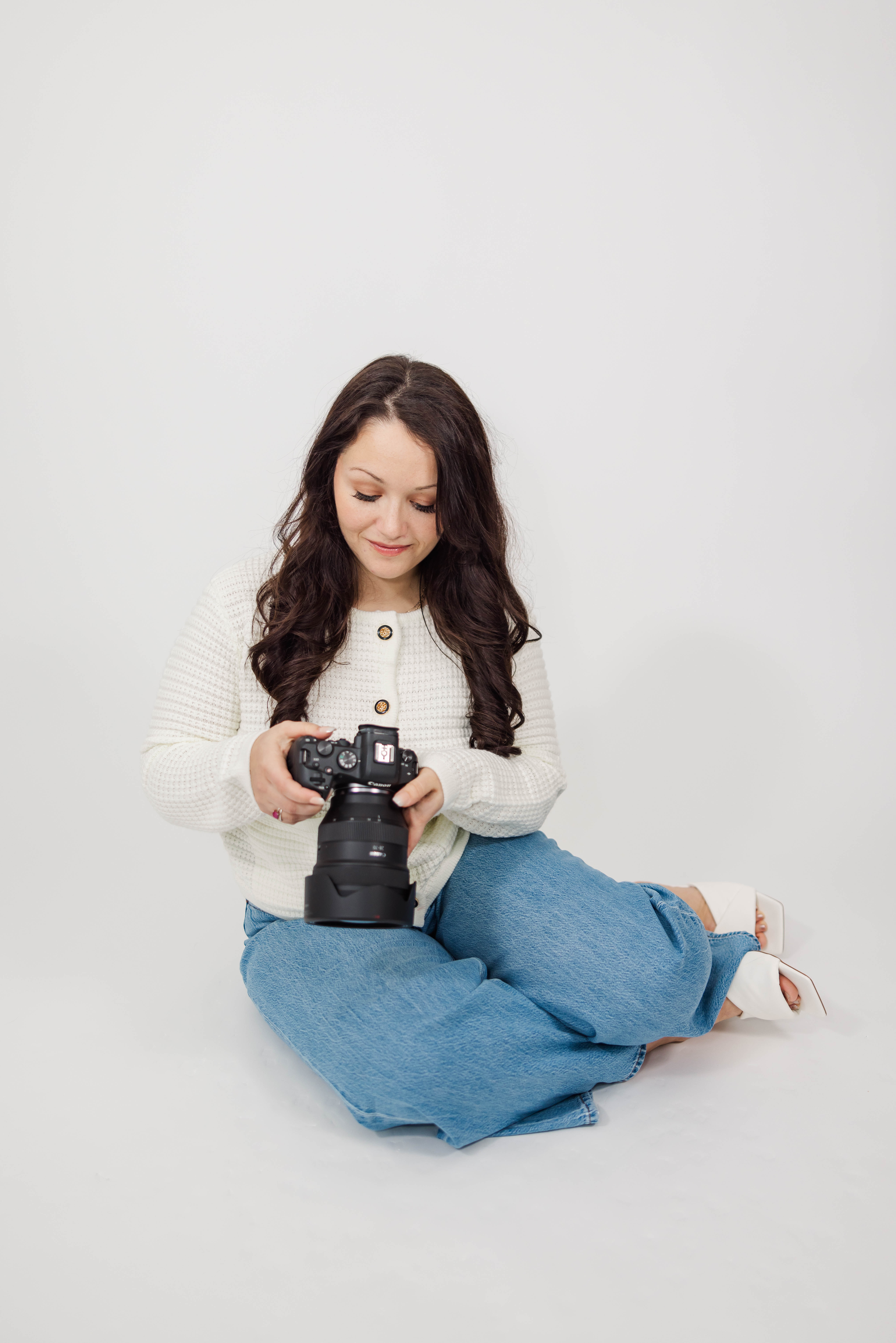 Photographer smiling in a casual black top and jeans during a branding photo session in Traverse City, Michigan