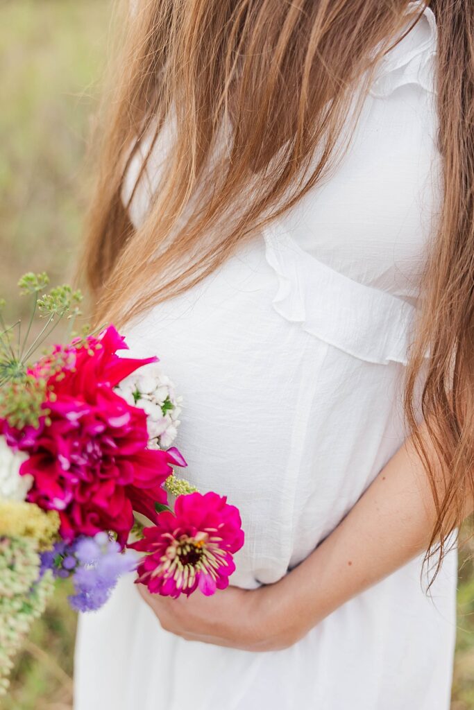Expecting mom holding her baby bump during a Traverse City maternity session