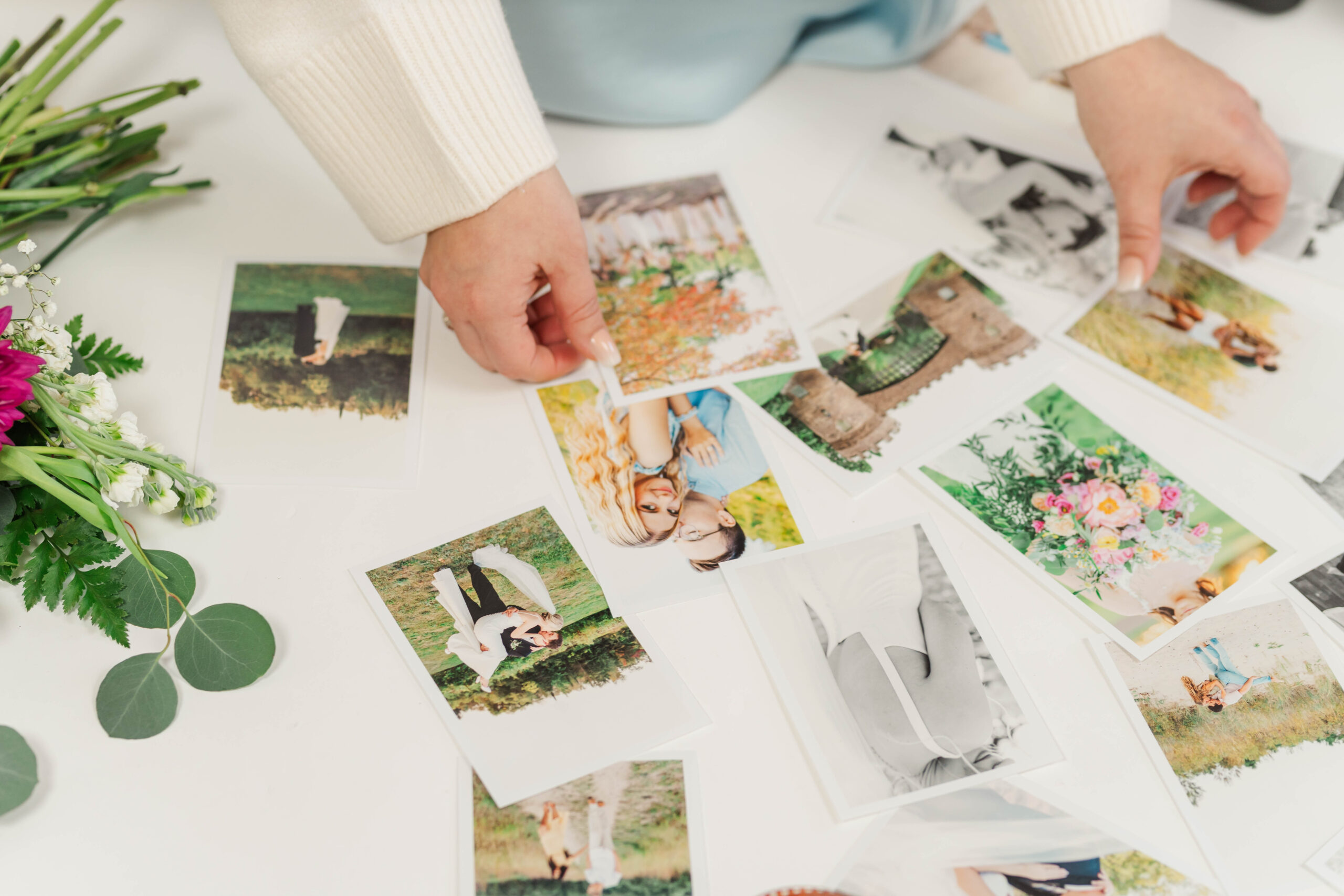Photographer sorting printed wedding photos on a table — an essential part of planning with a pre-wedding questionnaire