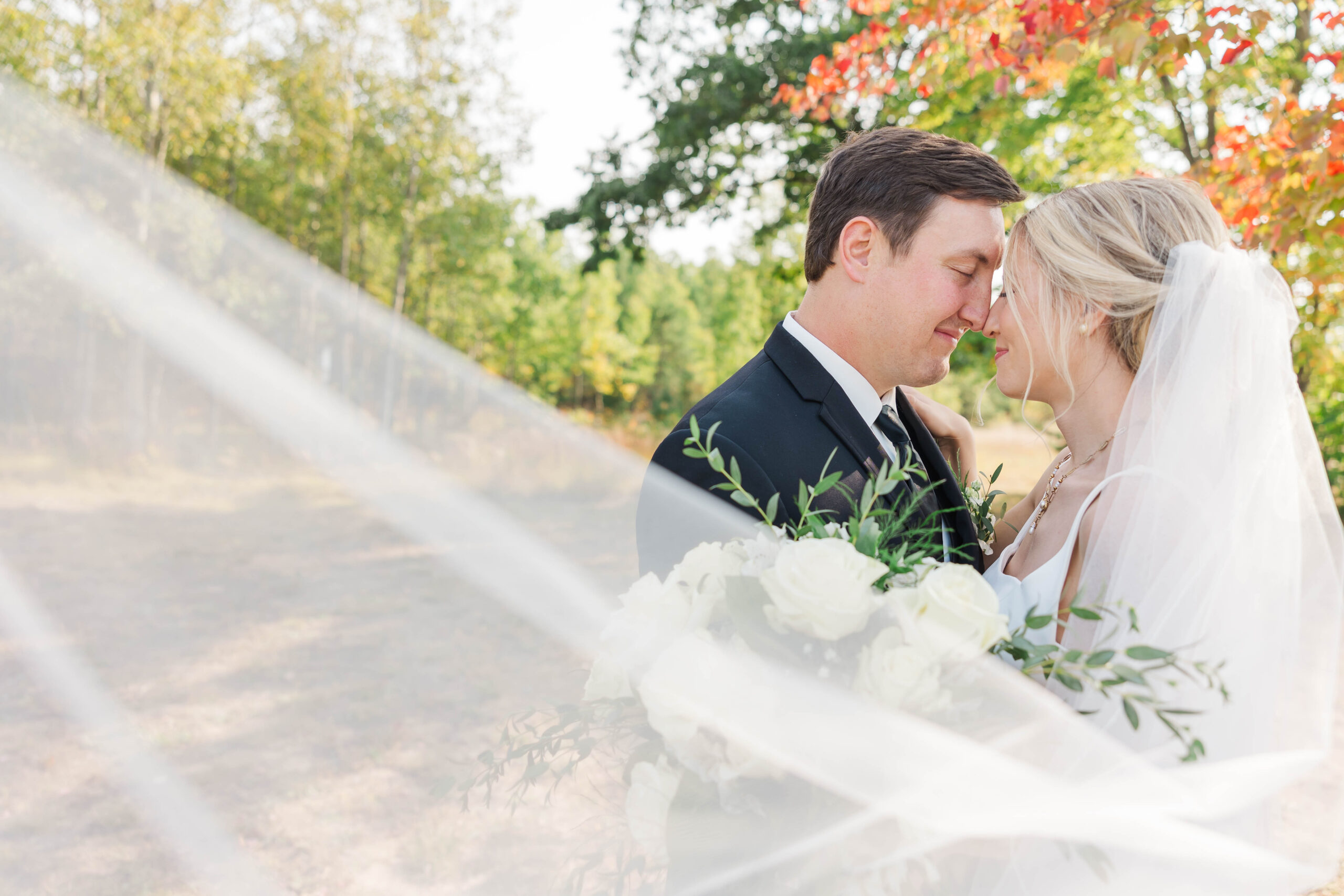 Bride and groom sharing a quiet moment on their wedding day with the veil flowing in front of them, Northern Michigan wedding