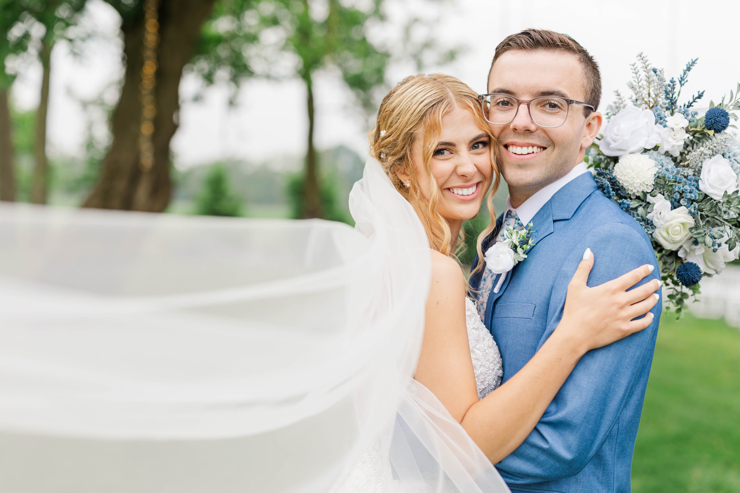 Bride and groom sharing a joyful moment on their elegant dusty blue Northern Michigan wedding day