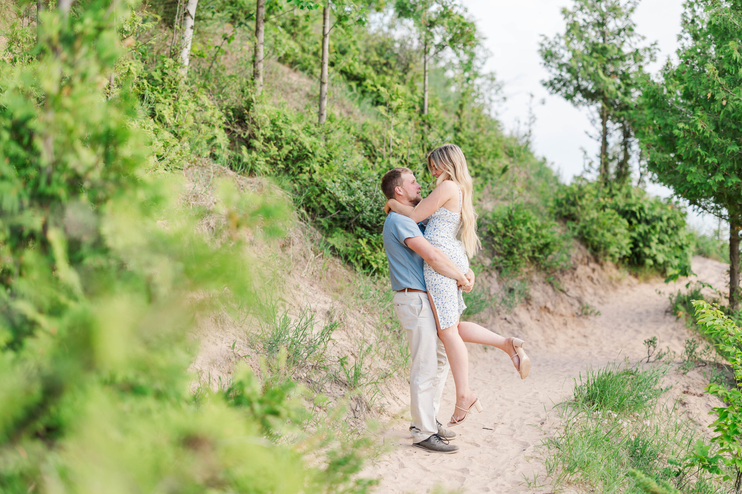 Couple holding each other during engagement session at Empire Bluff in Sleeping Bear Dunes.