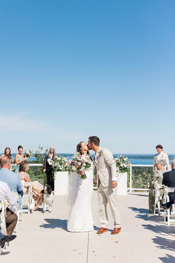 Couple sharing their first kiss during a Bayview wedding ceremony at Gallagher Farms