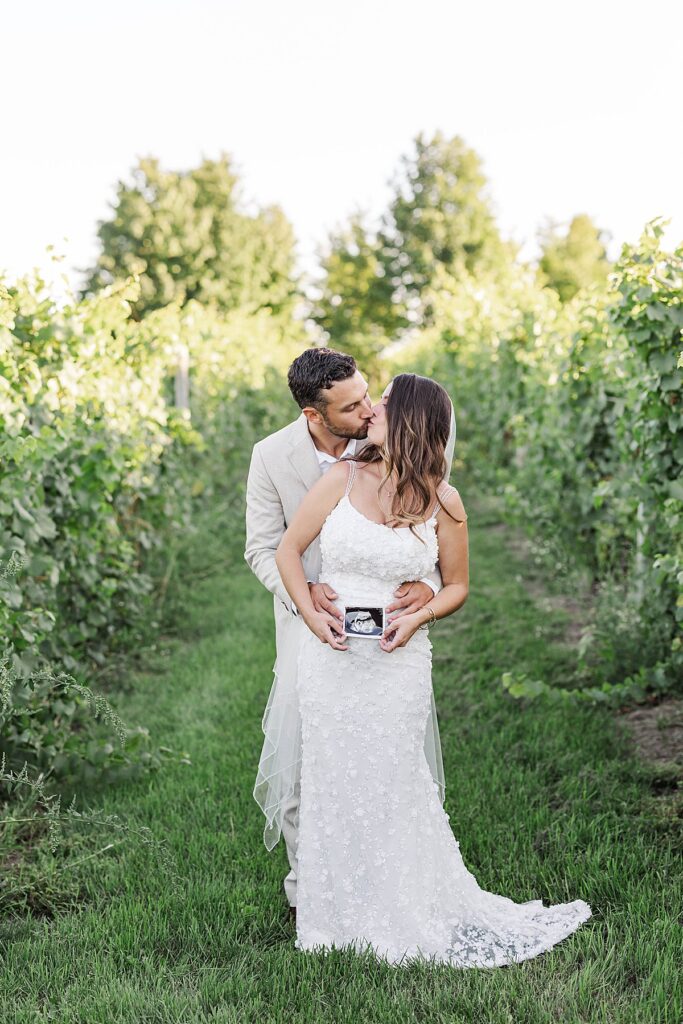 Newlyweds embracing in the orchard at Gallagher Farms during a Bayview wedding