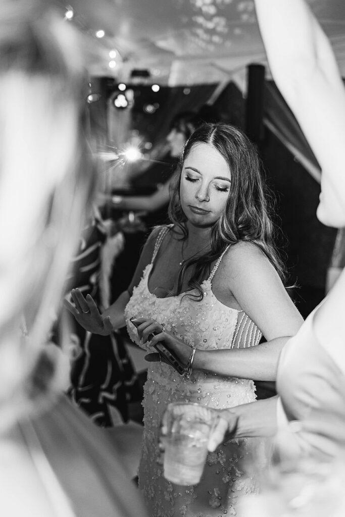 Bride dancing during the wedding reception at Gallagher Farms in black and white