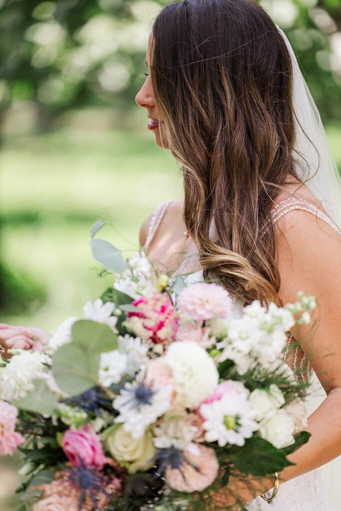 Bride holding bouquet during orchard portraits at Bayview Weddings