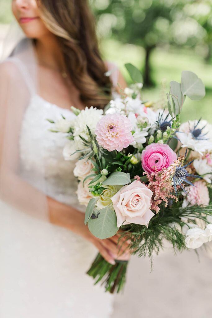 Bride holding a colorful floral bouquet during a Bayview wedding at Gallagher Farms