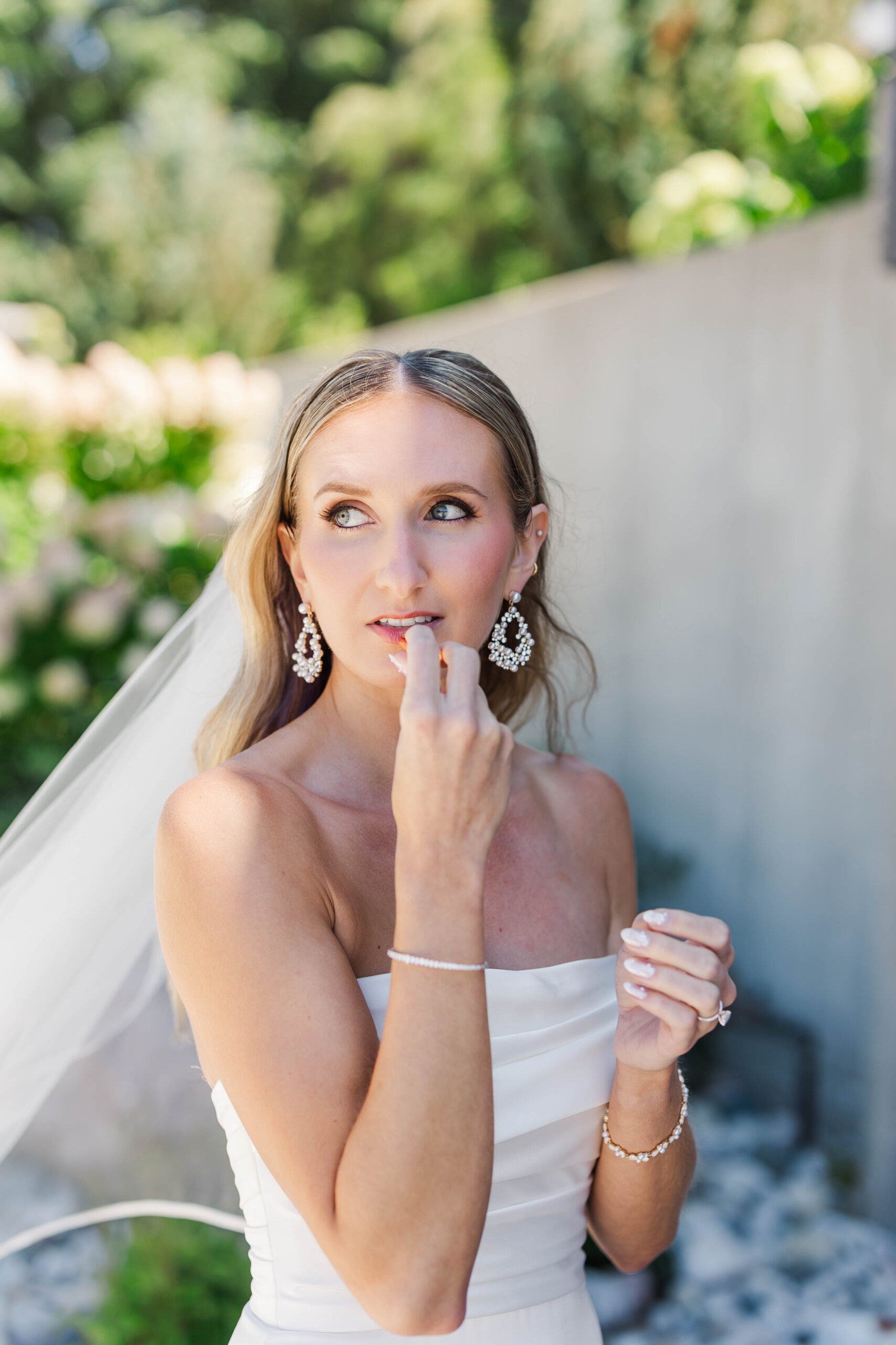 Bride Samantha putting on lipstick while getting ready at Heritage Wedding Barns in Shelby, Michigan before her Northern Michigan wedding.