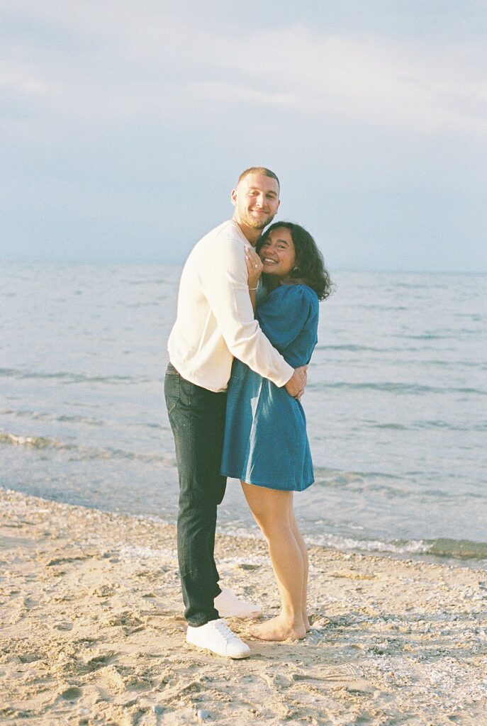 Couple celebrating their engagement on Elk Rapids beach captured on film