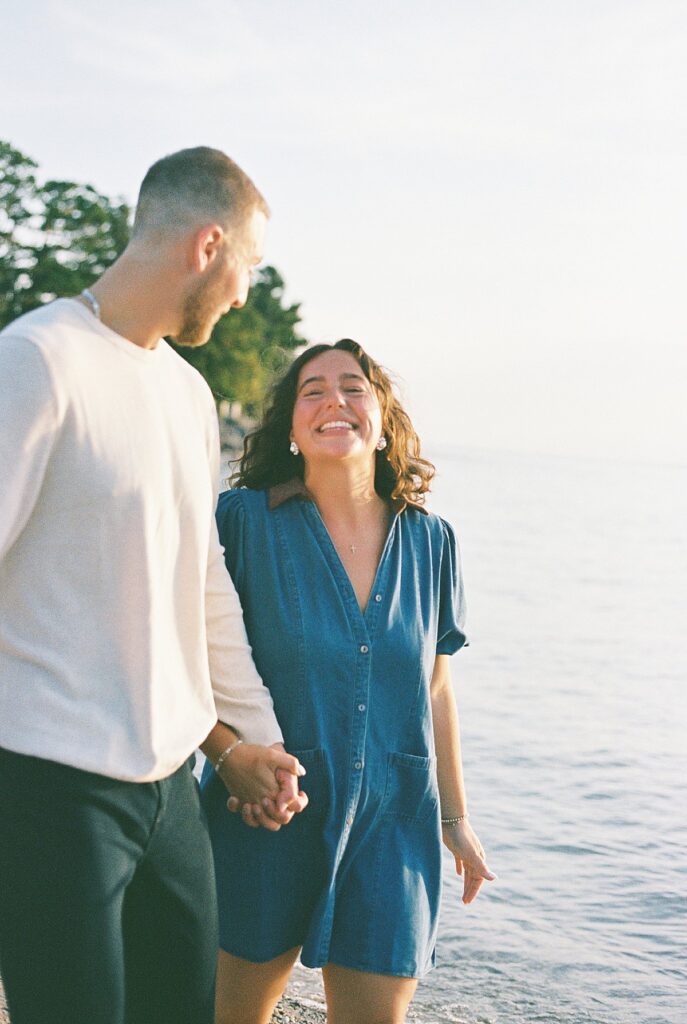 Newly engaged couple embracing on Elk Rapids beach in a film photograph