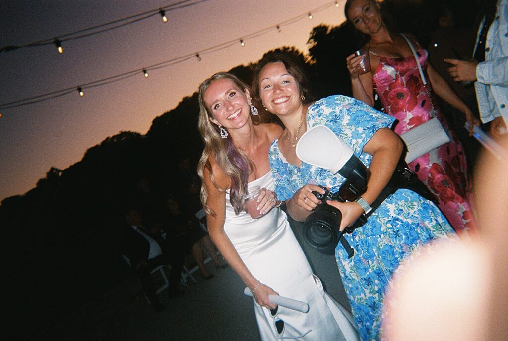 Bride with her photographer during the wedding reception, disposable camera photo