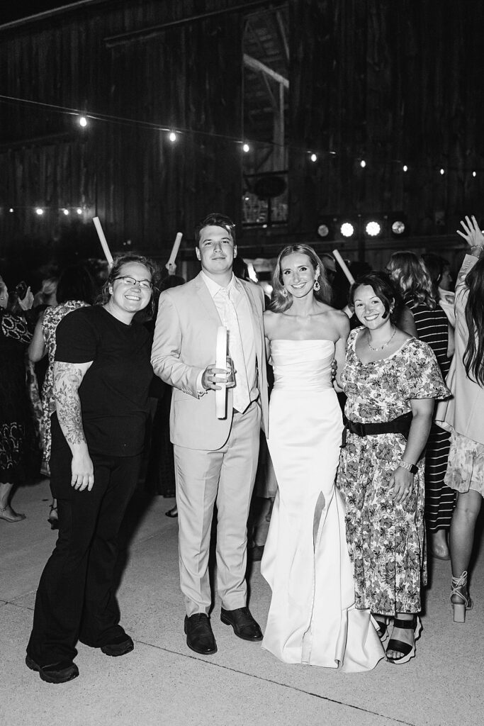 Black and white photo of the bride and groom with their photographers