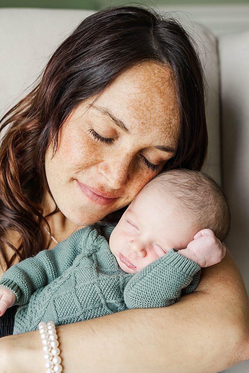 Mother and newborn photographed in soft natural light