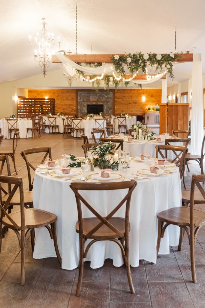 BlueBridge Events Centre reception space with wood beams, chandelier lighting, and round tables set for a Traverse City wedding