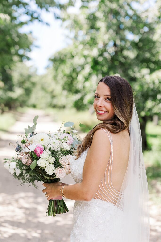 Bride holding a bouquet during Northern Michigan wedding portraits with soft natural light.