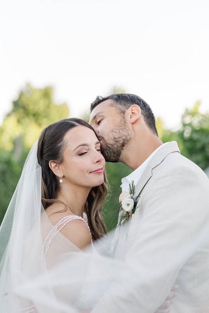 Romantic estate-style wedding portrait with soft veil movement
