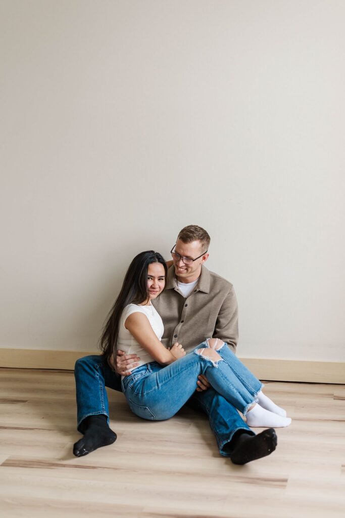 Couple sitting together during a cozy indoor Northern Michigan engagement session