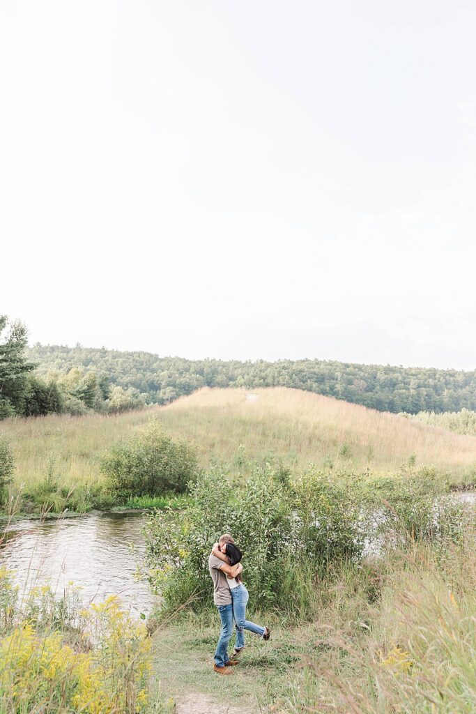 Brown Bridge Quiet Area engagement photos in Northern Michigan with river and rolling fields