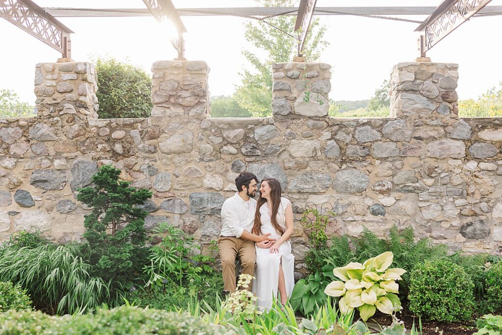maternity couple sitting in the walled garden at Botanical Gardens in Traverse City during a Northern Michigan portrait session