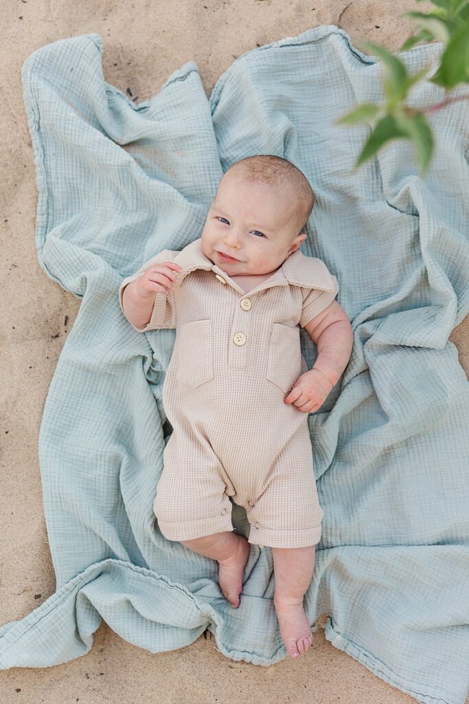 Northern Michigan newborn photography session with baby lying on blanket outdoors
