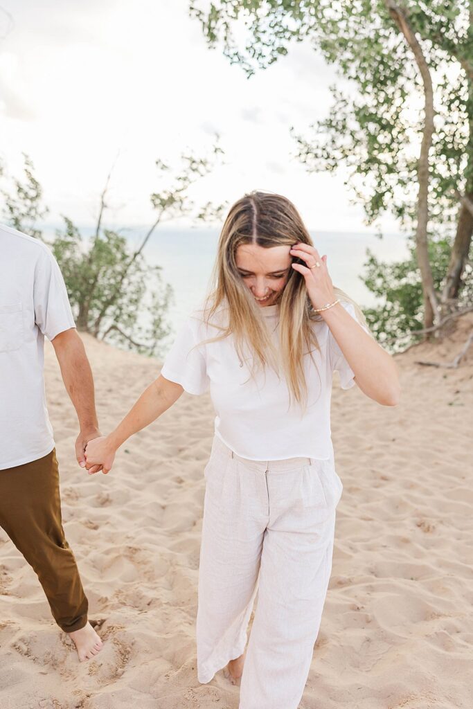 couple laughing and spinning at Pierce Stocking overlook in Sleeping Bear Dunes during a Northern Michigan portrait session