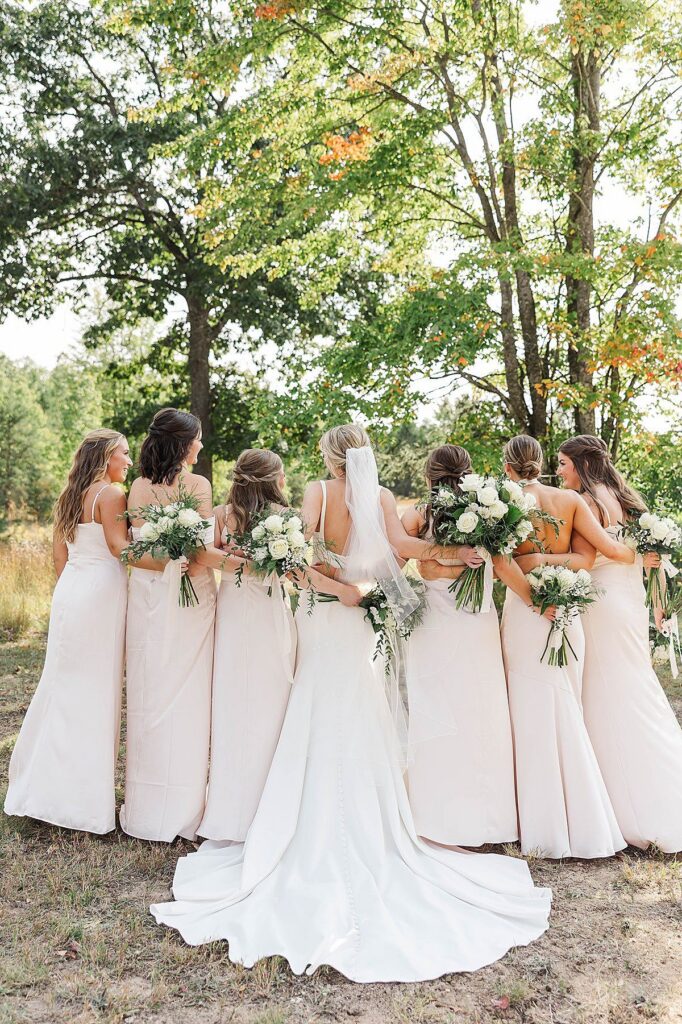 Bride with bridesmaids in fall colors during a Northern Michigan wedding celebration in autumn