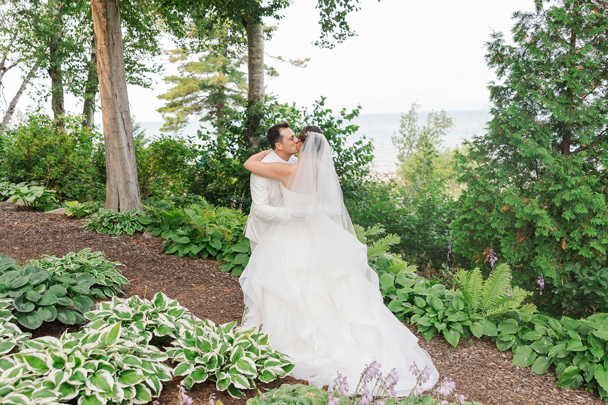 Romantic couple portrait with florals and waterfront views at a Petoskey Michigan wedding venue