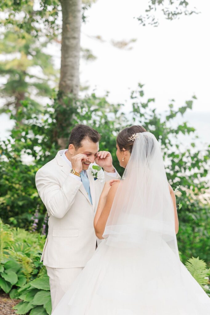 Romantic groom crying during an emotional first look at The Perry Hotel wedding in Petoskey, Michigan