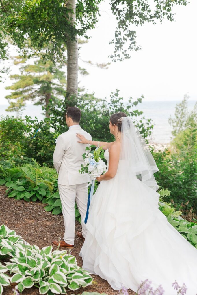 Bride approaching groom during a first look at Stafford’s Perry Hotel in Petoskey